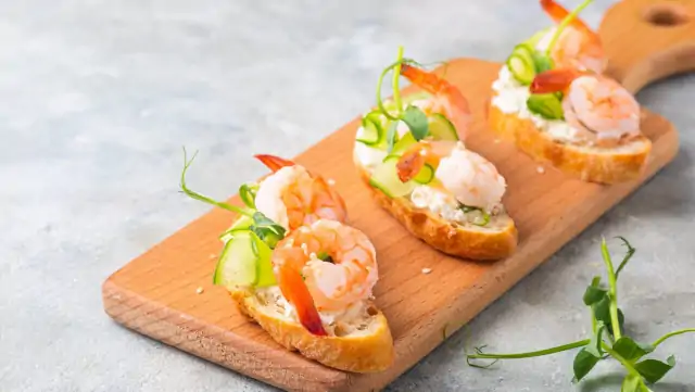 Shrimp smørrebrød on a wooden board, perfect Scandinavian-inspired picnic food ideas for a Singapore gathering.